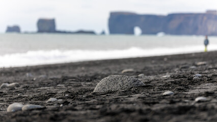 Rocks and sand on the black sand beach in Reynisfjara in Iceland on March 2024