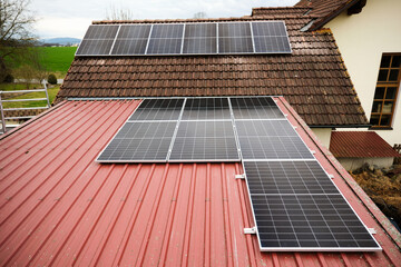 Solar panels are laid on the tin roof of a private house