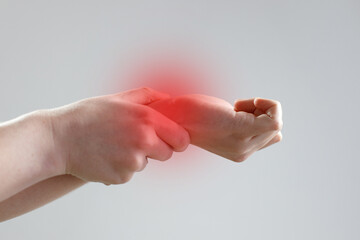 Close-up of a young woman holding her wrist. hand injury, feeling pain. Healthcare and medical...