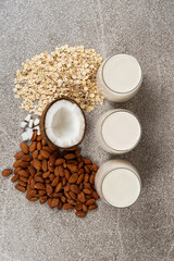 Types of plant-based milk in glasses. Oat, coconut and almond milk.