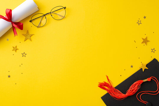 Milestone setting. Overhead perspective displaying graduation cap, rolled diploma, ribbon-tied, eyeglasses, and glitzy confetti on a vibrant yellow backdrop, leaving space for customized text