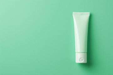 Minimalist cosmetic cream tube against a cool mint green isolated solid background, promoting a fresh and clean beauty regimen,