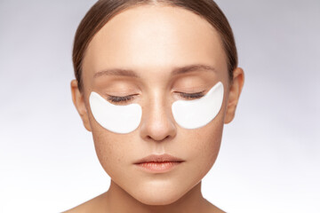 Closeup portrait of calm relaxed beautiful woman keeps eyes closed posing with under eye patches...