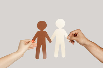 Closeup of woman and man hands two paper human symbol multiethnic friendship and relationship....