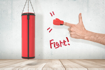Side view of man's hand with miniature red boxing glove