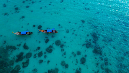 Traditional Thai longtail boat in the shallow waters of Phi Phi island, Krabi, Thailand. Boat tour in South East Asia concept.