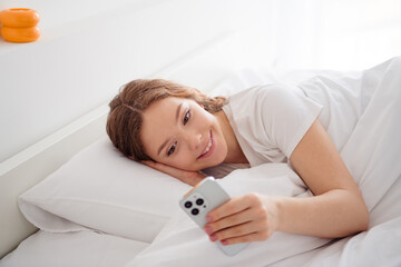 Portrait of lovely female person lay cozy bed pillow under blanket use smart phone typing texting...