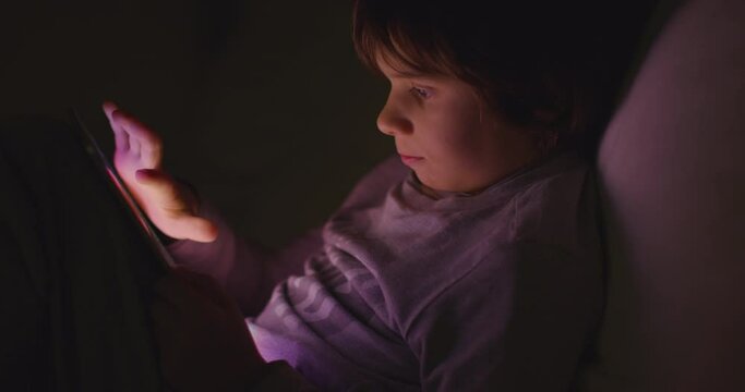Boy enjoy digital tablet at night