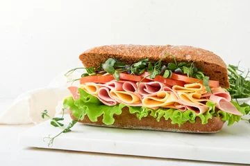 Badezimmer Foto Rückwand Sandwich. One fresh big submarine sandwich with ham, cheese, lettuce, tomatoes and microgreens on light background. Healthy breakfast theme concept, school lunch, breakfast or snack. © kasia2003