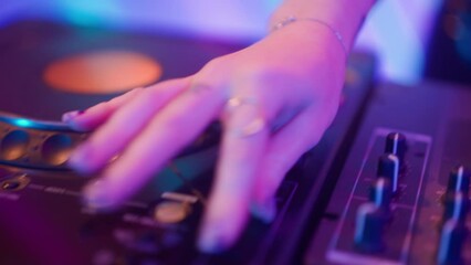 Close up shot of female hands on music mixer. Young woman dj dancing, mixing plays music on turntables mixer at night club.