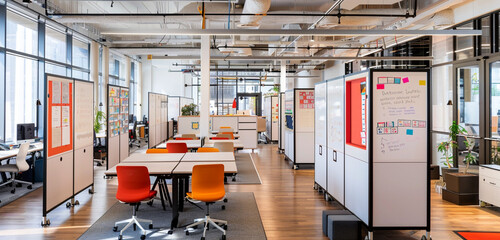 A collaborative workspace with movable partitions, adjustable-height desks, and floor-to-ceiling whiteboards for brainstorming and ideation sessions