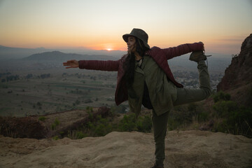Young mexican girl enjoying the sunriese in the top of a mountain
