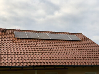 Solar panels on the roof of a house with red tiles