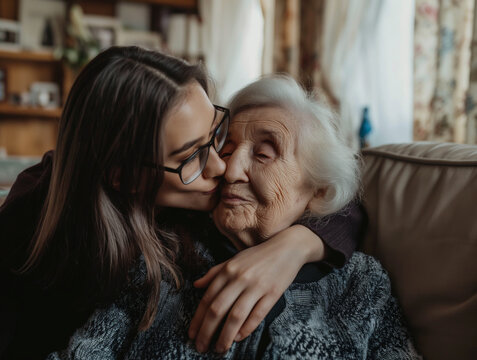 Young woman kissing her mother in the home. Mother's Day concept