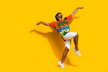 Fototapeta na wymiar Full length photo of nice guy wear hawaii print shirt look at sale empty space dance arm like wings isolated on yellow color background