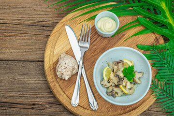 Rapana clam meat with oil, spices and greens. Healthy seafood is rich in omega. Marine decor