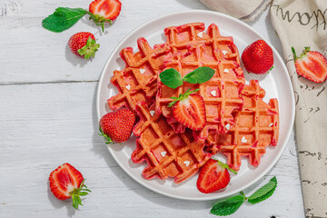 Homemade Belgian Waffles with strawberries. Gluten-free red dessert, fresh fruits and basil