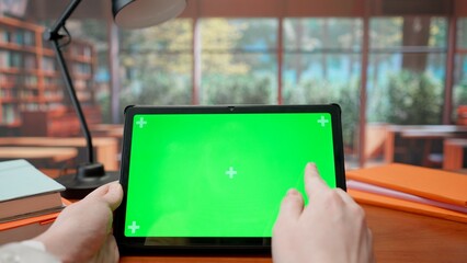 Tablet with Green Screen on Library Desk. Advertising area, workspace mock up.