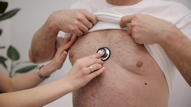 Female doctor use stethoscope to listen heart of mature man patient. Nurse home visit, checking health of old senior male. Close-up