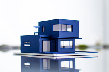 A modern indigo-colored miniature house, reflecting a sense of depth and sophistication against a bright white backdrop.