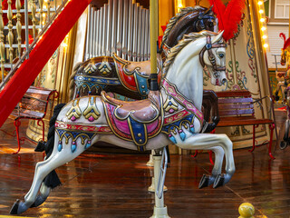 Fototapeta na wymiar beautiful horses on rotating carousel in the amusement park in the evening