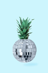 Creative concept disco ball and pineapple on bright blue background. Minimal food concept.