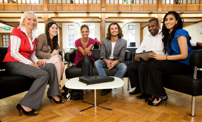 Open Meeting. A group of relaxed young professionals sitting to discuss a group project in their...