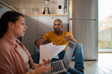 Man and woman discussing paperwork in kitchen