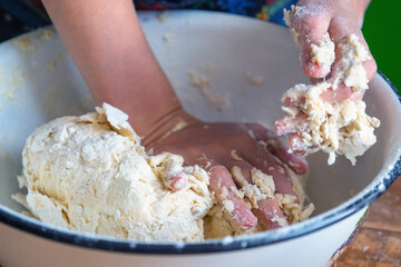 An experienced chef in a professional kitchen prepares the dough with flour to pizza. Food, the art of cooking and handmade concept. Horizontal image.