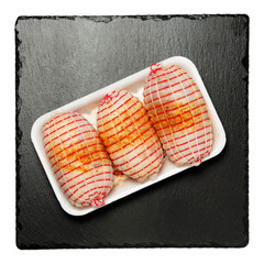 three raw chicken rolls on black stone isolated - 769939243