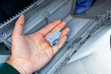 Hand removing lint from a clothes dryer filter, home maintenance - 769942094