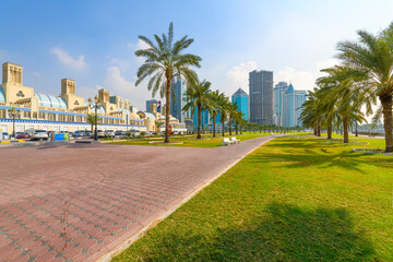 View from Central Souk Park of the Blue Souq shopping mall and downtown Sharjah skyline from the waterfront Corniche at Sharjah, United Arab Emirates, December 9 2023. - obrazy, fototapety, plakaty