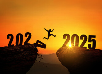 Man jumping on cliff 2025 over the precipice with stones at amazing sunset. New Year's concept....