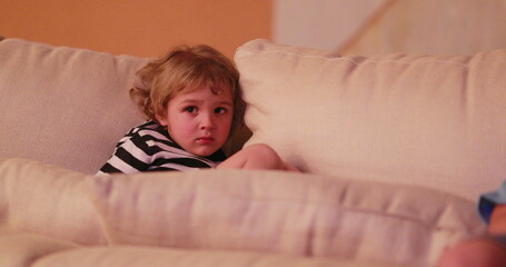 Candid child watching TV screen, toddler hypnotized by content