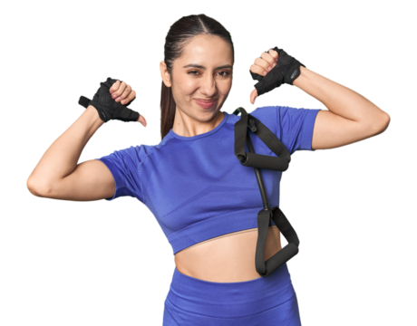 Athletic young Caucasian woman with resistance band on studio background feels proud and self confident, example to follow.