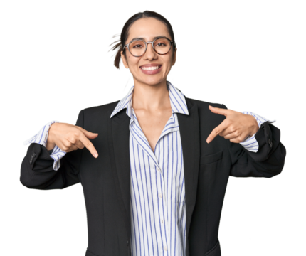 Confident young Caucasian businesswoman on studio background points down with fingers, positive feeling.