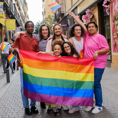 A group of people are holding a rainbow flag and posing for a picture
