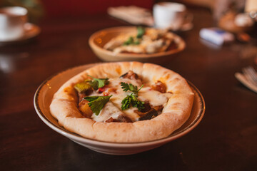 A savory dish of veal and roast vegetables in tomato sauce, presented in an artisanal edible bread pot.