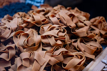 Italian food, dried handmade colorful pasta pappardelle with saffron, ready to cook, Milan, Lombardy, Italy