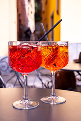 Aperol and Campari Spritz orange bitter long drink cocktails made with liqueur, prosecco sparkling wine, ice cubes and piece of orange, Milan, Italy