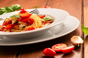 Piatto di classici spaghetti con olio di oliva, pomodorini e basilico, pasta italiana, dieta...