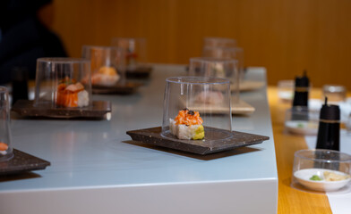 Japanese cuisine, modern restaurant with sushi, sashimi, other Japanese dishes served on moving...