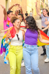 lesbian couple, and a group of people are holding rainbow flags and smiling