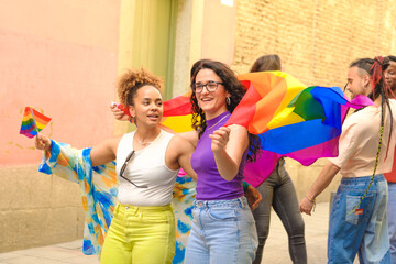 lesbian couple, and a group of people are holding rainbow flags and smiling