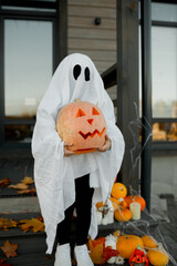 ghost kid for halloween in autumn decoration witg pumpkin