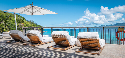 Relax and summer vacation concept: Luxury loungers at the pool on tropical destination.