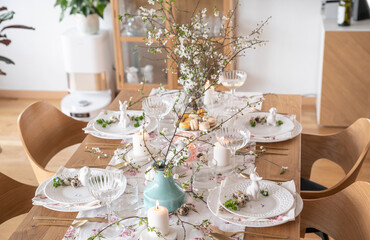 Spring Easter decor. Easter table setting. Flowers and dishes and candles for a festive dinner. 