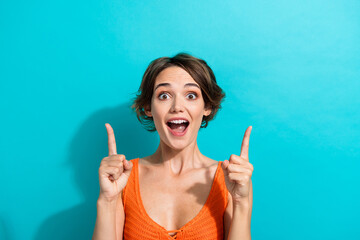 Portrait of impressed ecstatic girl wear orange knit top indicating at impressive discount empty...