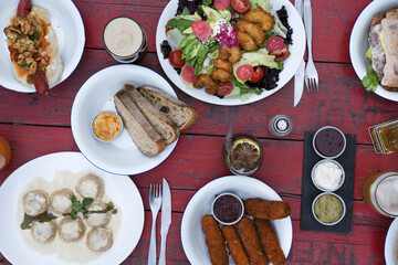 Top view of the restaurant table with drinks and many gourmet dishes