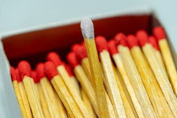 Set of several defocused grey headed matchsticks with one pink-headed matchstick in evidence.